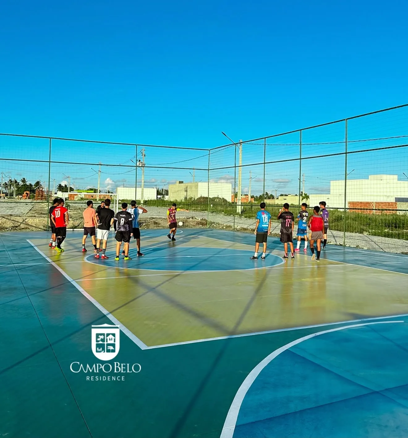 Quadra poliesportiva com jovens jogando futebol